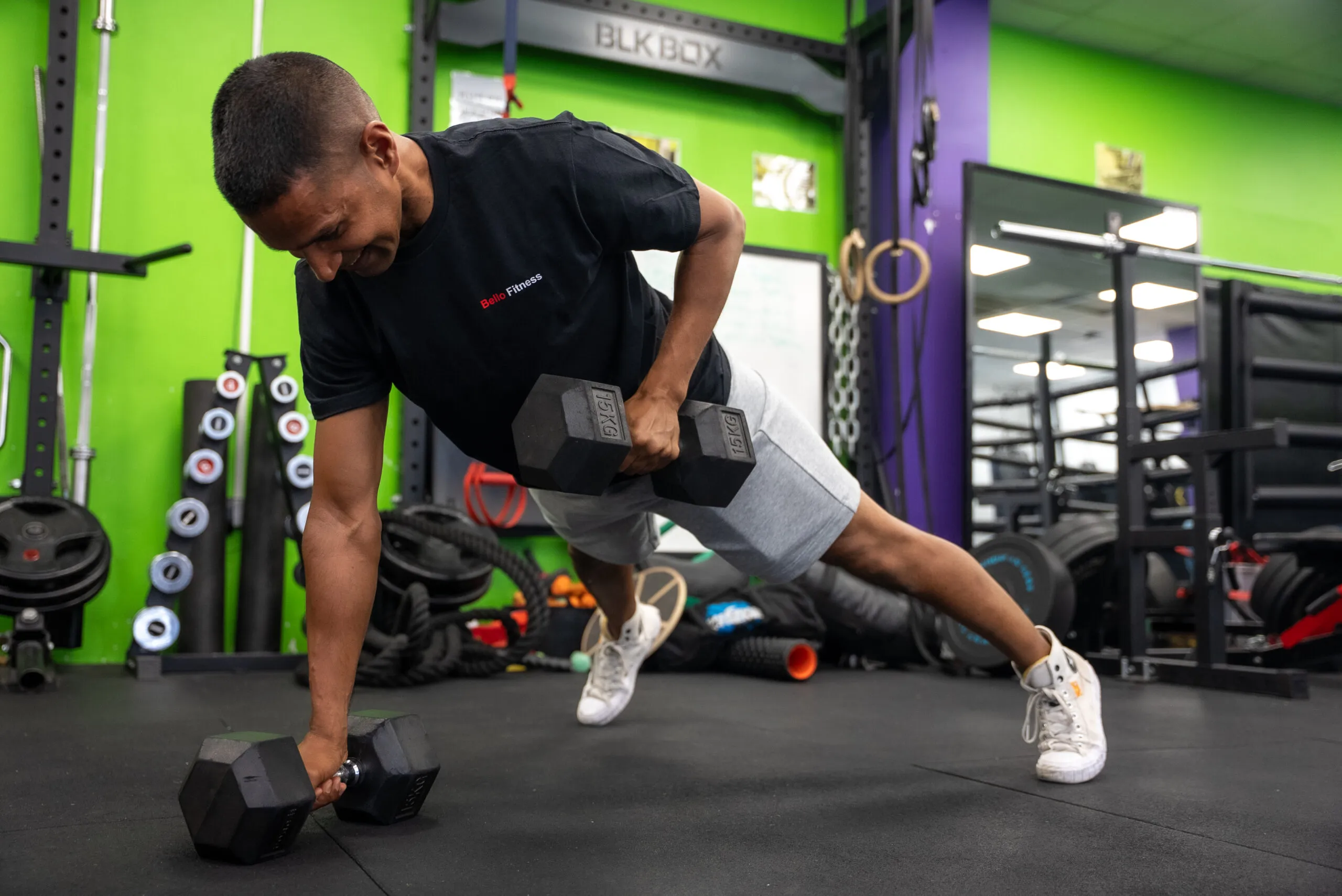 A learner performing a renegade row on the gym floor